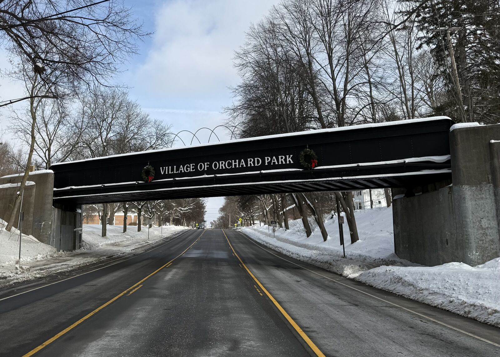 Village of Orchard Park railroad bridge gateway over a snowy road